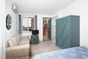 a living room with a couch and a tv at Hotel Villino Gallodoro in Taormina
