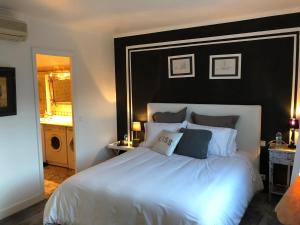 サントロペにあるPerrine Duplexのベッドルーム(白い大型ベッド1台、黒いヘッドボード付)