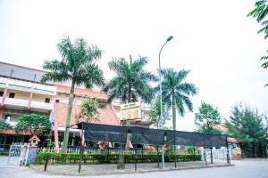 um palco em frente a um edifício com palmeiras em Star Hotel Hai Duong em Hải Dương