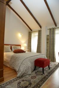 a bedroom with a large bed with a red chair at Casa da Fraga in Ferreira +40 photos