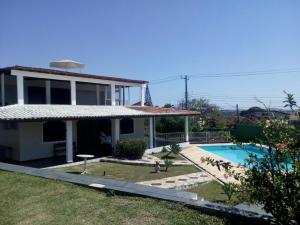 a house with a swimming pool in front of it at Pousada Tourne Bride in Araruama