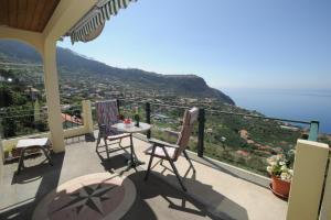 een balkon met een tafel en stoelen en de oceaan bij Casa Daniela in Calheta +11 foto's