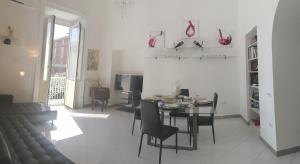 a dining room and living room with a table and chairs at ReggiaHome Apartment in Caserta