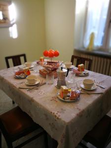 una mesa con un mantel blanco con comida. en Casa Bruno B&B en Mondovì
