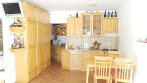 a kitchen with wooden cabinets and a table and chairs at Julija Podkoren in Kranjska Gora