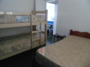 two bunk beds in a small room with a bed at Sunny apartamentos de 1 e 2 dormitórios na Martin de Sá próximo a praia in Caraguatatuba