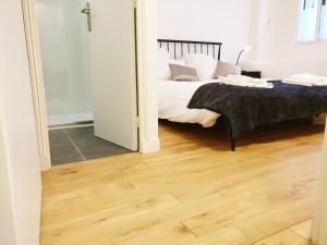 een slaapkamer met een bed en een houten vloer bij 3 double bedrooms apartment in Montmartre near subway AC in Parijs
