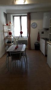 サン・タンドレ・レ・ザルプにあるchez les fillesのテーブル付きの部屋、時計付きのキッチンが備わる客室です。