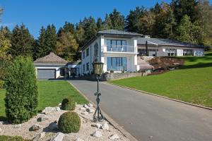 a large white house with a driveway at View & Garden Villa Schauenstein in Schauenstein