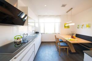 a kitchen with a wooden table and a kitchen with a dining table at View & Garden Villa Schauenstein in Schauenstein