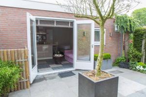 un patio con una puerta corredera y un árbol en Bed & Bike Studio Amsterdam en Ámsterdam