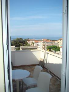 a balcony with white chairs and a view of the ocean at Apartments Ada in Tučepi