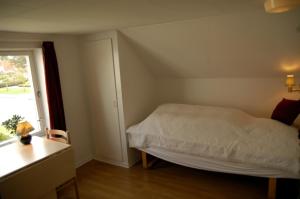 a small bedroom with a bed and a window at Nr. Nebel Overnatning Hostel in Nørre Nebel