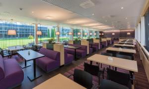 a restaurant with purple furniture and tables and windows at Spa Tervis in Pärnu