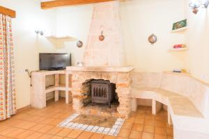 a living room with a stone fireplace and a tv at Sa Cunia in Campos