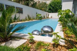 een zwembad met zilveren ballen in een tuin bij Le Clos Labottière - B&B in Bordeaux