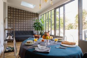 una mesa con un paño de mesa azul y fruta en ella en Le Clos Labottière - B&B en Burdeos