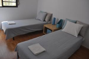 リスボンにあるF! Lisbon Guest Houseのベッド2台とソファが備わる客室です。