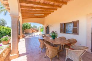 un patio al aire libre con mesa de madera y sillas en Clau De Sol en Can Picafort