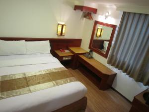 A bed or beds in a room at Gau Shan Ching Hotel