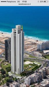 una vista aerea di un alto edificio bianco vicino all'oceano di View of Paradise a Bat Yam