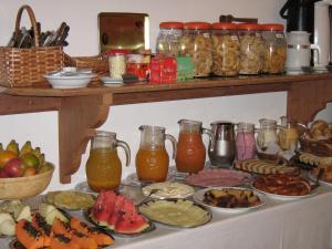 Pousada Amaryllis في تيرادينتيس: طاولة مليئة بمختلف أنواع الطعام والمشروبات