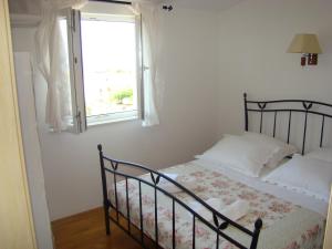 um quarto com uma cama e uma janela em Apartments Ada em Tučepi