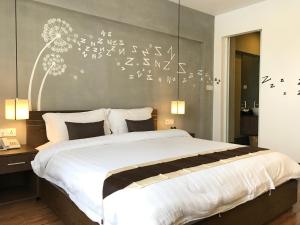 a bedroom with a large bed with flowers on the wall at Asiban Quay Boutique Hotel in Phnom Penh