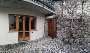 um edifício com uma porta e uma árvore ao lado em La Casa delle Fate em Solto Collina