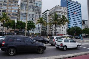 grupa samochodów zaparkowanych na ulicy miejskiej z budynkami w obiekcie Apartamento Conjugado Copacabana w mieście Rio de Janeiro
