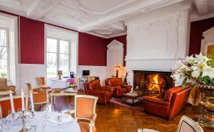 a living room with red walls and a fireplace at Château de Bellefontaine - Teritoria in Bayeux