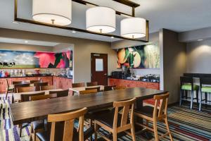 a dining room with a large wooden table and chairs at Comfort Inn & Suites Olathe - Kansas City in Olathe
