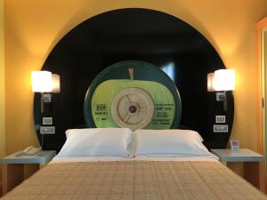 a bedroom with a bed with a green apple clock at Guglielmotel in Brembate