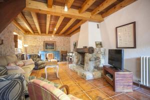 a living room with a fireplace and a tv at Can Guillo in Pollença