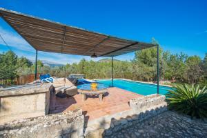 an outdoor patio with a table and a pool at Can Guillo in Pollença