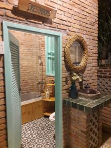 a bathroom with a sink and a tub and a mirror at Nam Thi Holiday Home in Cai Be