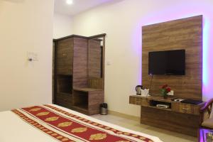 a living room with a television and a room at Regal Hotel and restaurant in Mathura