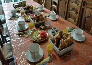 a table with a breakfast of croissants and fruit at Chambres D'hôtes du Plessis in Chailles