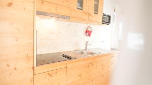 a kitchen with a sink and wooden cabinets at Hellweger Apartments in Anterselva di Mezzo +44 photos