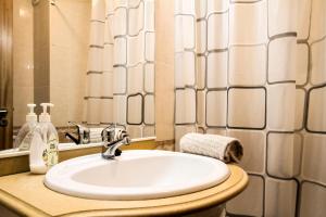 a bathroom with a white sink and a mirror at Apartamento do Avô Tomás in Madalena do Mar +16 photos