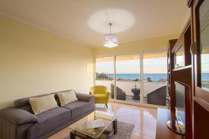 a living room with a couch and a view of the ocean at Apartamento do Avô Tomás in Madalena do Mar