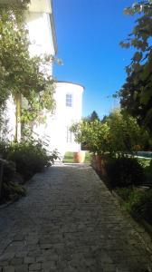 a cobblestone walkway in front of a white building at Gasthof Ginzinger in Mauerkirchen