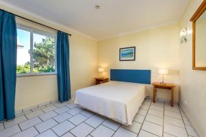 a bedroom with a bed and a large window at Club Ouratlantico in Albufeira