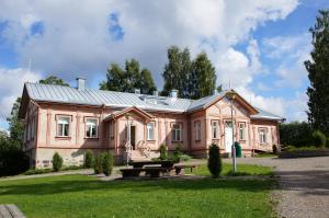 una gran casa rosa con techo de metal en Savonlinnan Kansanopisto - Wanha Pappila, en Savonlinna