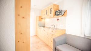 una pequeña cocina con fregadero y sofá en Hellweger Apartments, en Anterselva di Mezzo