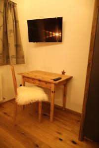 una mesa de madera con TV en la pared en Chaletwohnung-Schustern en Sankt Ulrich am Pillersee