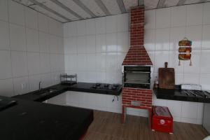 cocina con horno de ladrillo en una habitación en Condomínio Maura, en Porto Seguro