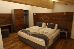 Schlafzimmer mit einem großen Bett mit einem Kopfteil aus Holz in der Unterkunft Chaletwohnung-Schustern in Sankt Ulrich am Pillersee