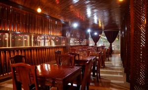 a row of wooden tables and chairs in a restaurant at Chang Palace Vientiane in Vientiane