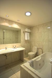 a bathroom with a tub and a toilet and a sink at Congo Palace in Athens